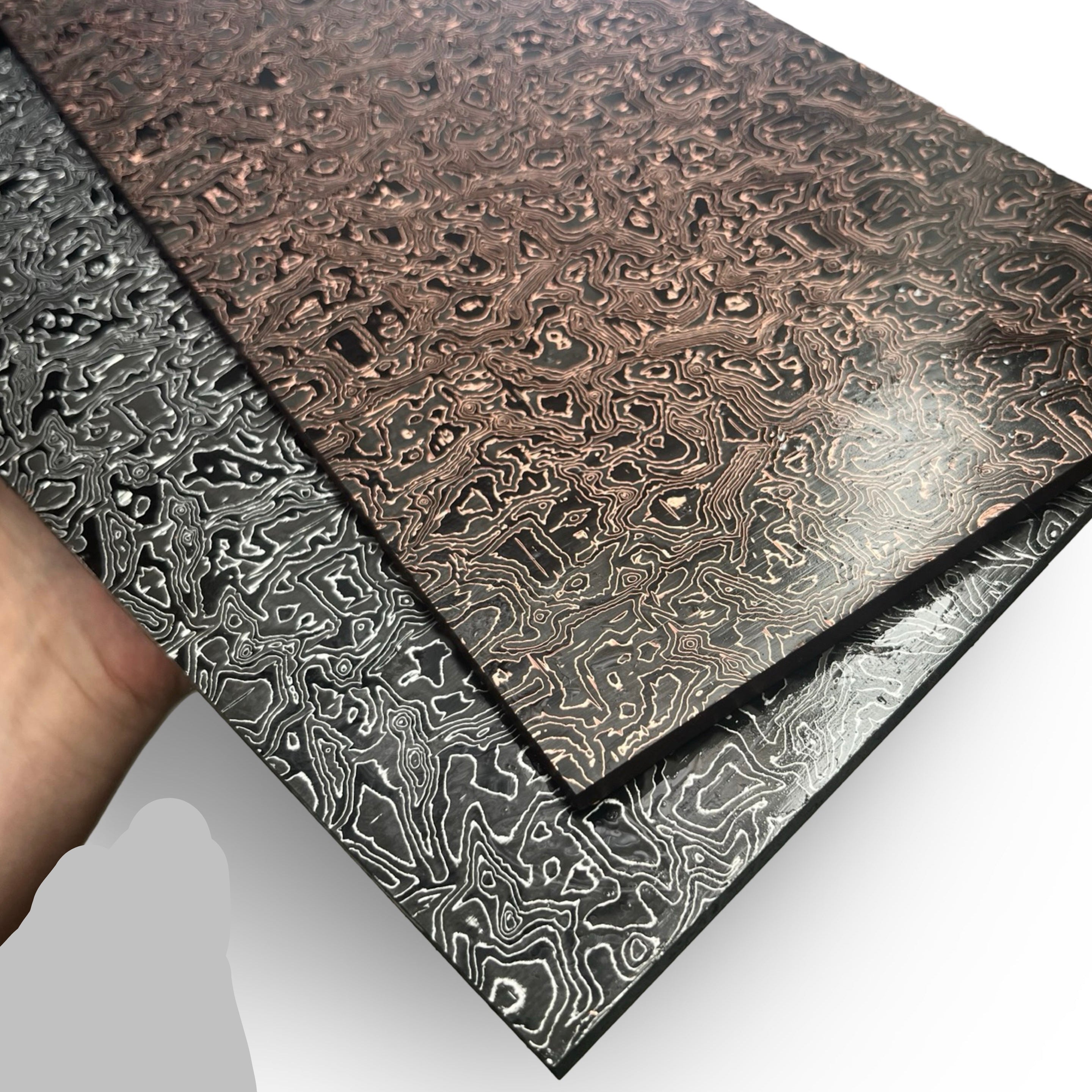 Two metal sheets with embossed patterns on a white background