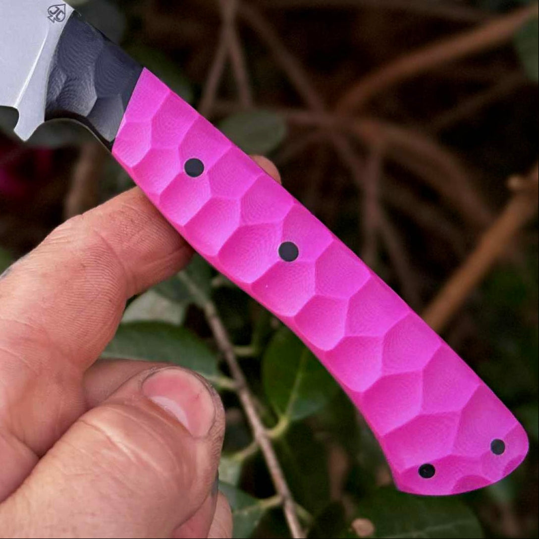 Hand holding a pink handle against a natural background